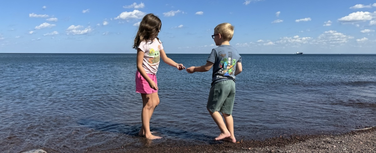 Gus and Charlee sharing a moment along the shoreline of Lake Superior, August 2024